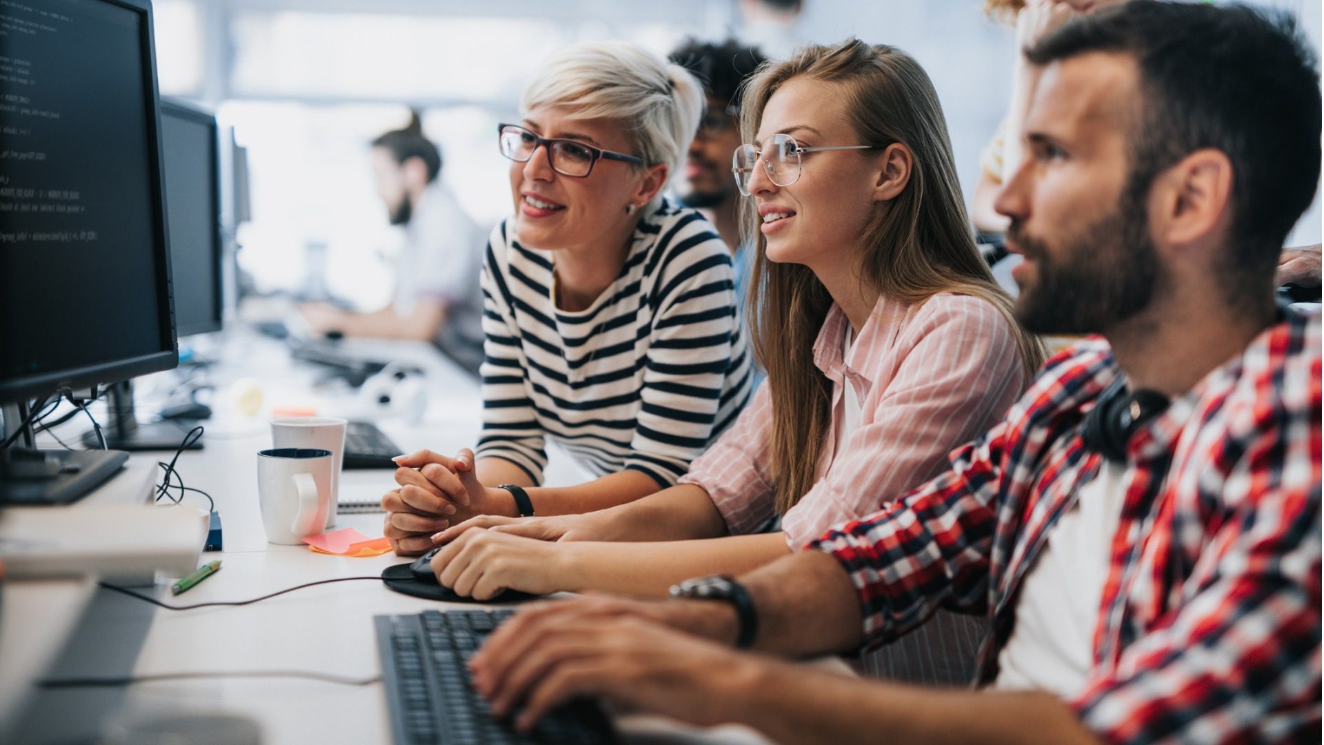 team-of-young-computer-programmers-cooperating-while-working-on-pc-picture-id1171890979