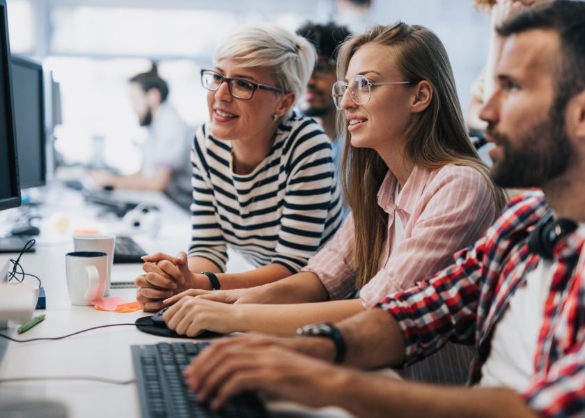 team-of-young-computer-programmers-cooperating-while-working-on-pc-picture-id1171890979