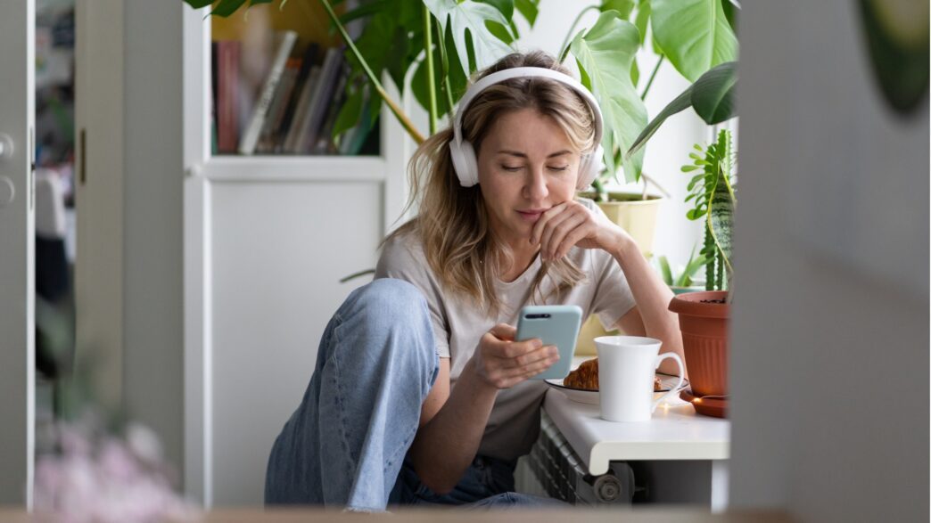 woman-listening-to-music-wear-wireless-white-headphones-using-mobile-picture-id1299480266-1044×587